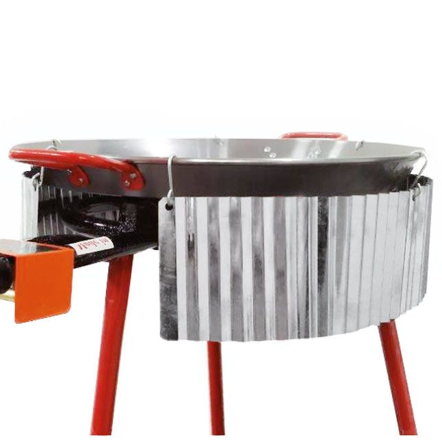 A silver corrugated stainless steel wind shield mounted on a cooking pan.