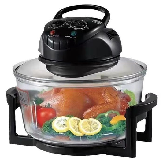 A countertop air fryer with a black plastic control lid and base, a clear glass bowl, and a transparent lid, shown with food inside on a white background.